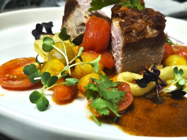 Rosa gebratener Iberico Rücken mit Kim-Chi-Gurken und geschmorten Tomaten